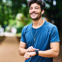 A man touching his watch after a run near Cypress McKinney Falls in Austin, Texas