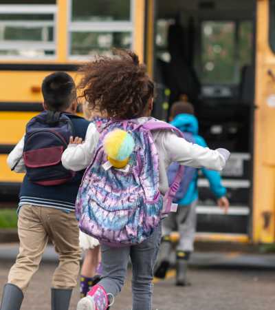 Kids running towards school bus near The Edison at Madison in Madison, Alabama