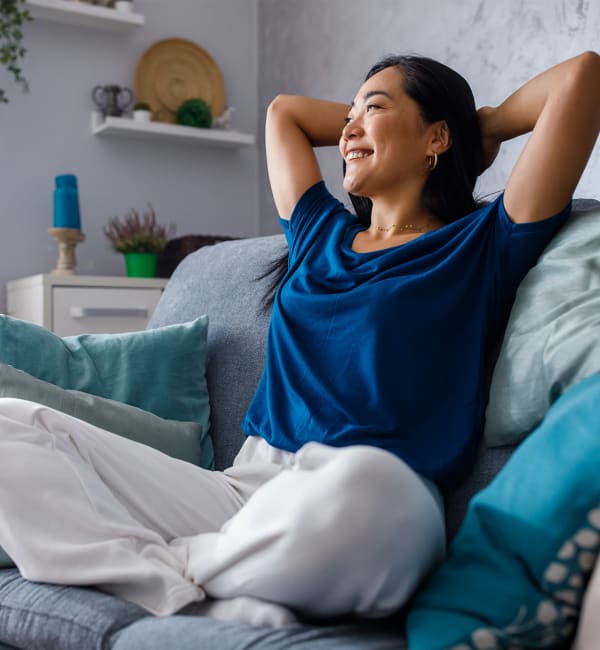 A resident relaxing on her couch at Lullwater at Blair Stone in Tallahassee, Florida