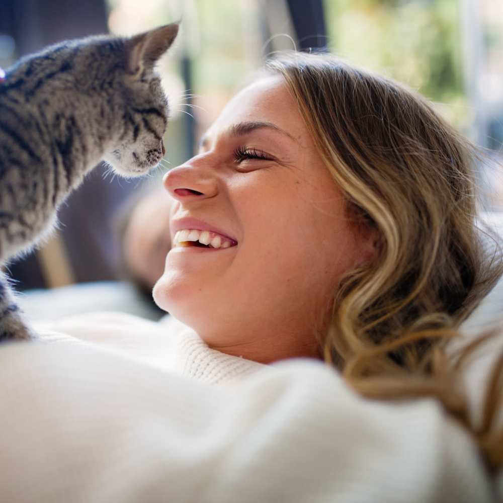 Resident playing with her cat on the bed at Ruby Vista in Denver, Colorado
