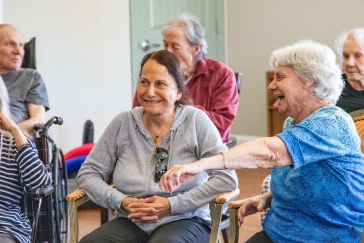 Residents at The Landing at Stone Oak share laughter and connection during a group activity, reflecting the community’s focus on friendship, engagement, and joyful living.