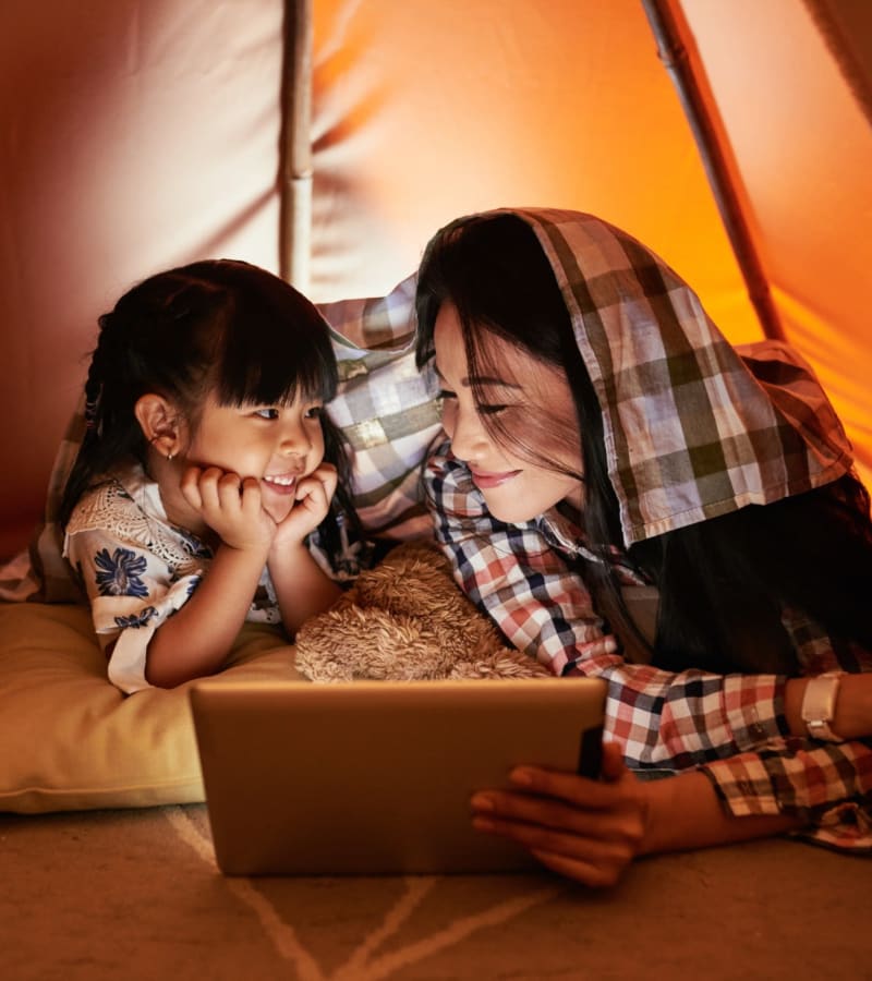 Mother and daughter watching a movie on a tablet inside a cozy tent in their home at Pointe at Northern Woods in Columbus, Ohio