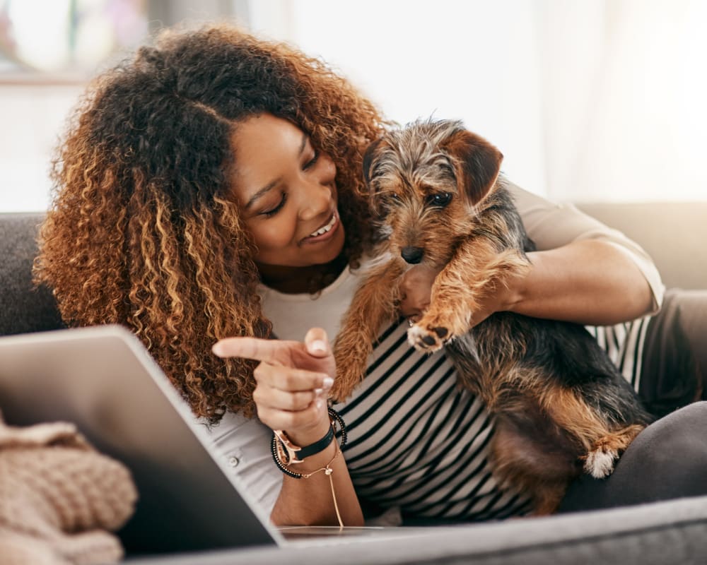 Resident and her dog relaxing on a couch at The August Apartments in Lexington, Kentucky