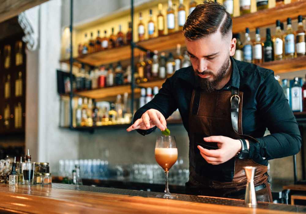 Bartender preparing a drink at a local bar near North Road Townhomes in Scottsville, New York