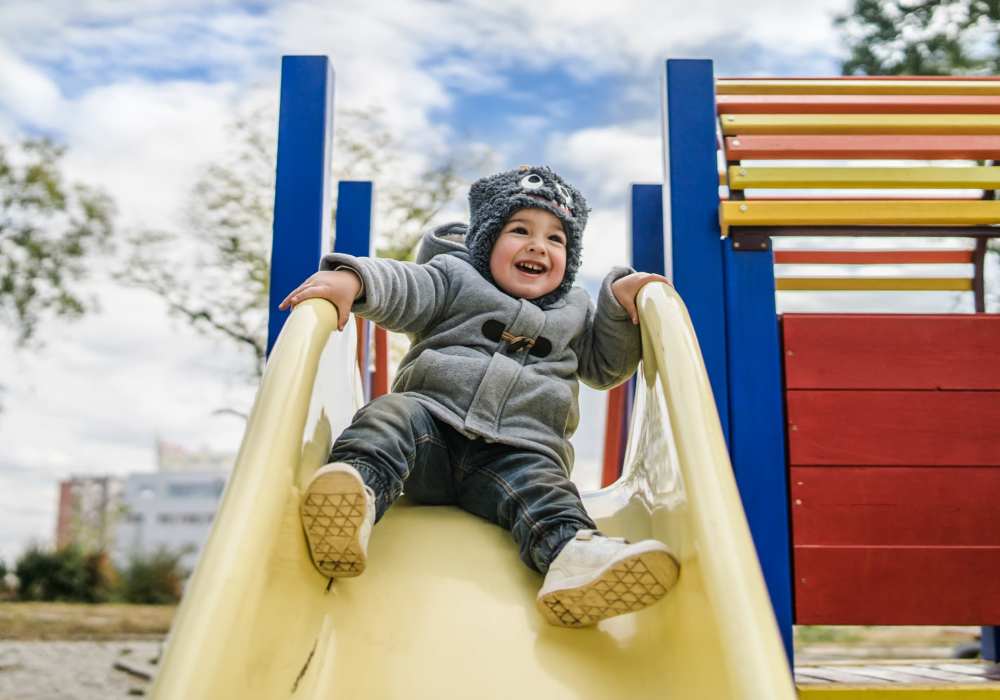 Kid playing on slide in playground at The Gardens At Pryor Creek in Pryor, Oklahoma