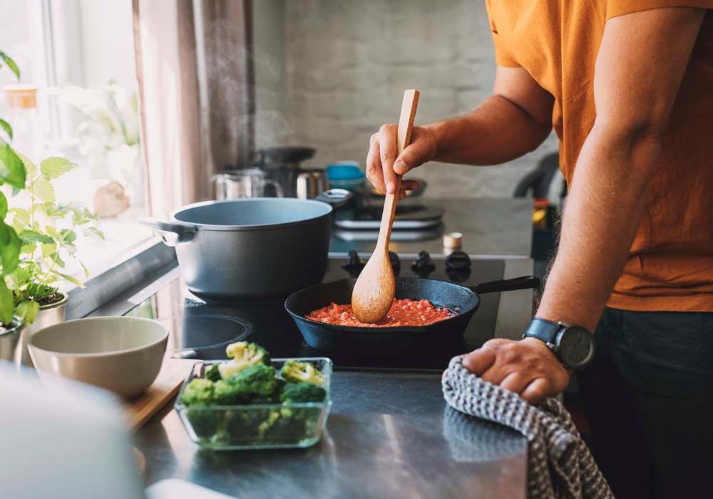 Resident cooking in kitchen at Cypress Point in Mooresville, North Carolina