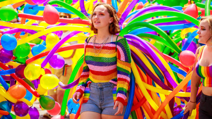 Pride Events in the Pearl young woman in front of pride baloons