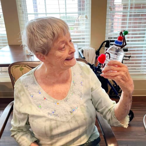 Beaming resident holding a craft at The Oxford Grand Assisted Living & Memory Care in McKinney, Texas