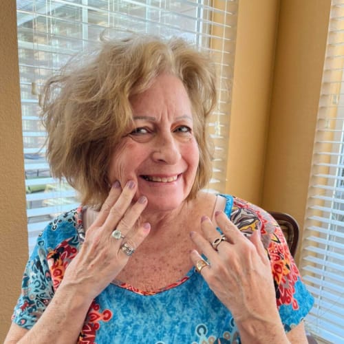 Resident walking and smiling at Oxford Glen Memory Care at Carrollton in Carrollton, Texas