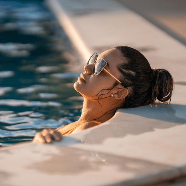 Woman relaxing at the poolside at The Abbey at Grande Oaks in San Antonio, Texas