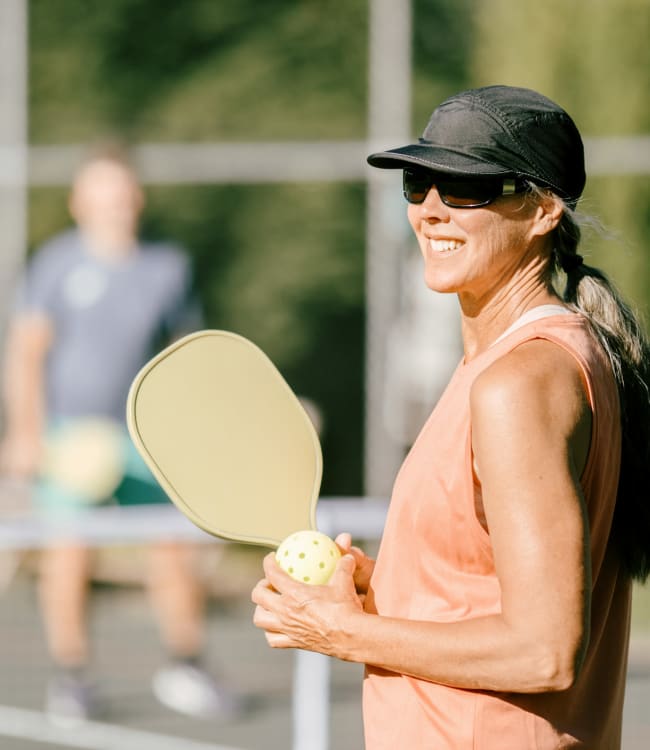 Mature Woman Playing Pickleball Game On Summer Morning at Estoria Cooperative Lakeville in Lakeville, Minnesota