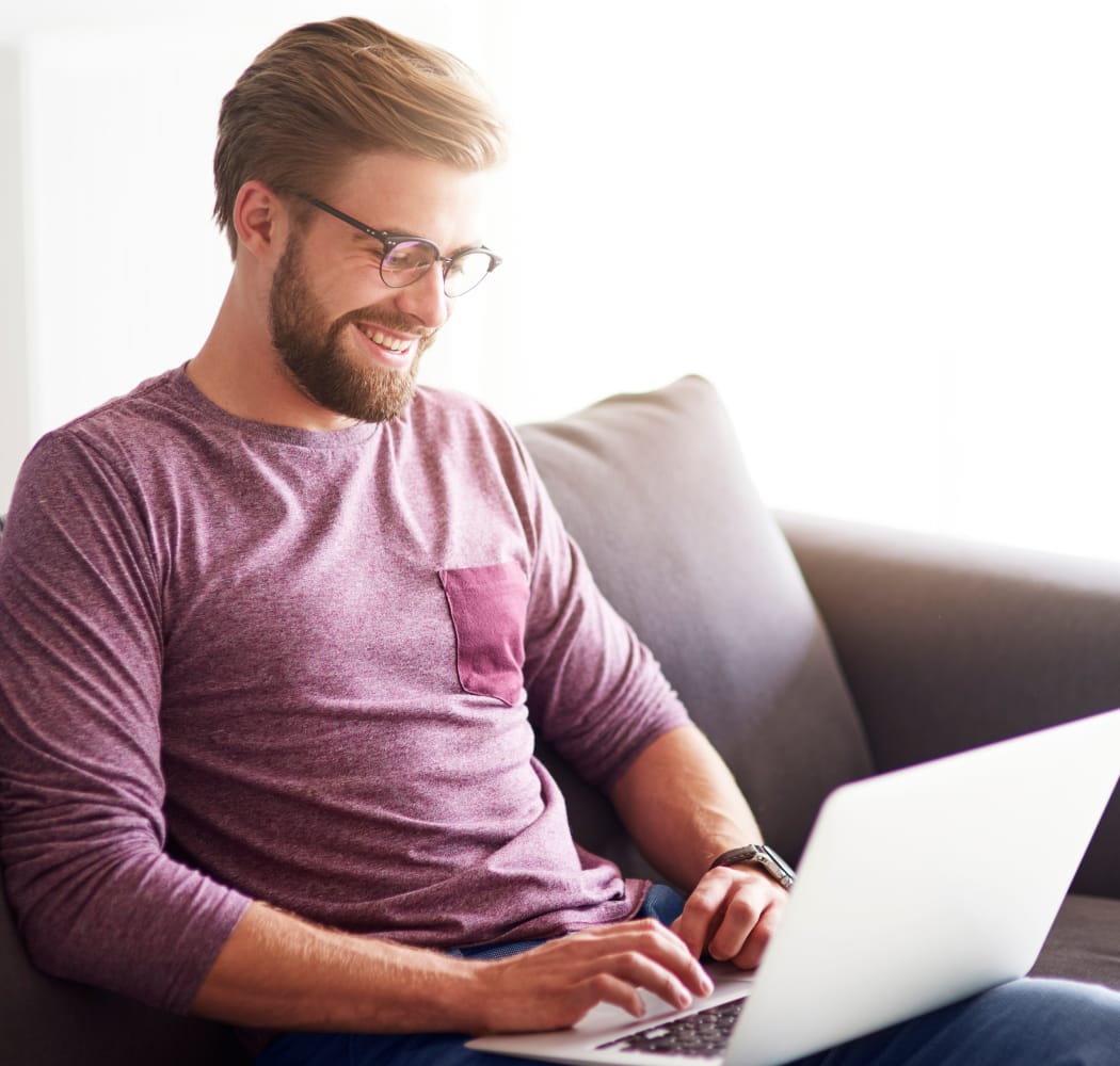 Man reading from his computer at Sunchase Apartments in Tulsa, Oklahoma