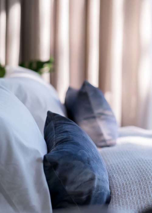 A well-made bed in an apartment bedroom at The Lynd Company in San Antonio, Texas