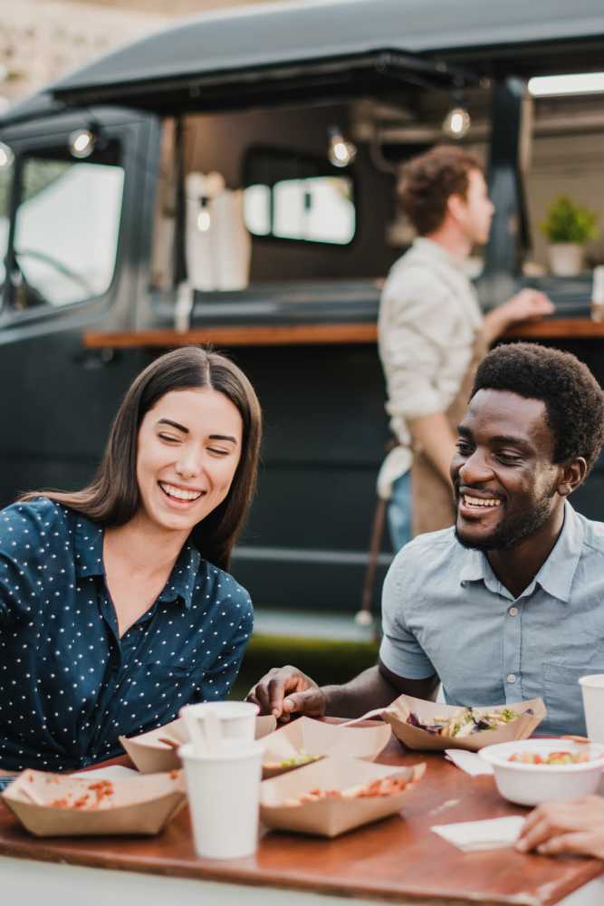 Resident couple grabbing a bite to eat from a food truck near Arcos in San Antonio, Texas
