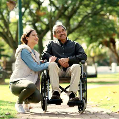 Woman with a Gentleman in a wheelchair at a park near Harbor Cove Apartments in Foster City, California