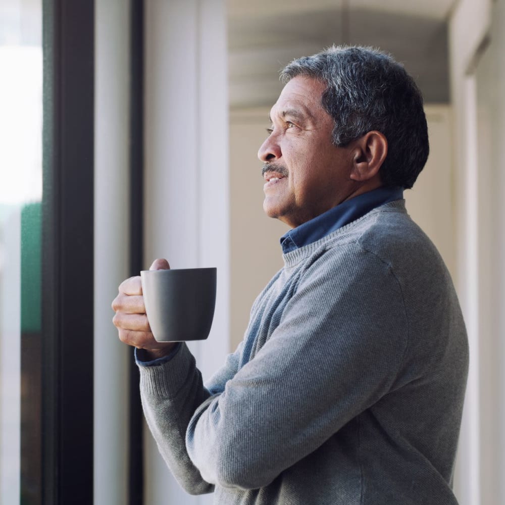 Resident drinking coffee in his apartment at Auburn Villas Senior Apartments in Auburn, California