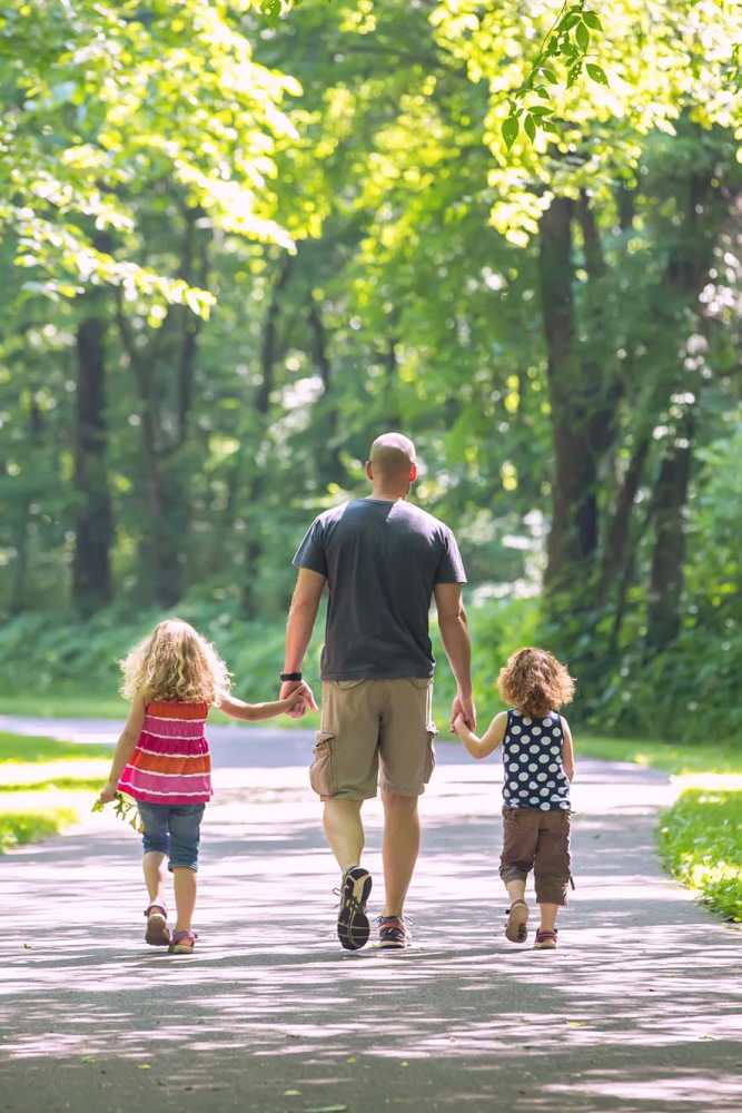 Resident walking with his children near Arbor Park Apartments in Hurst, Texas