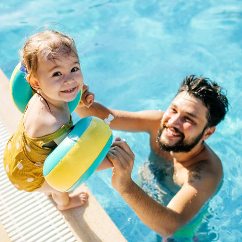 A child and father at the pool at Indigo Champions Ridge in Davenport, Florida