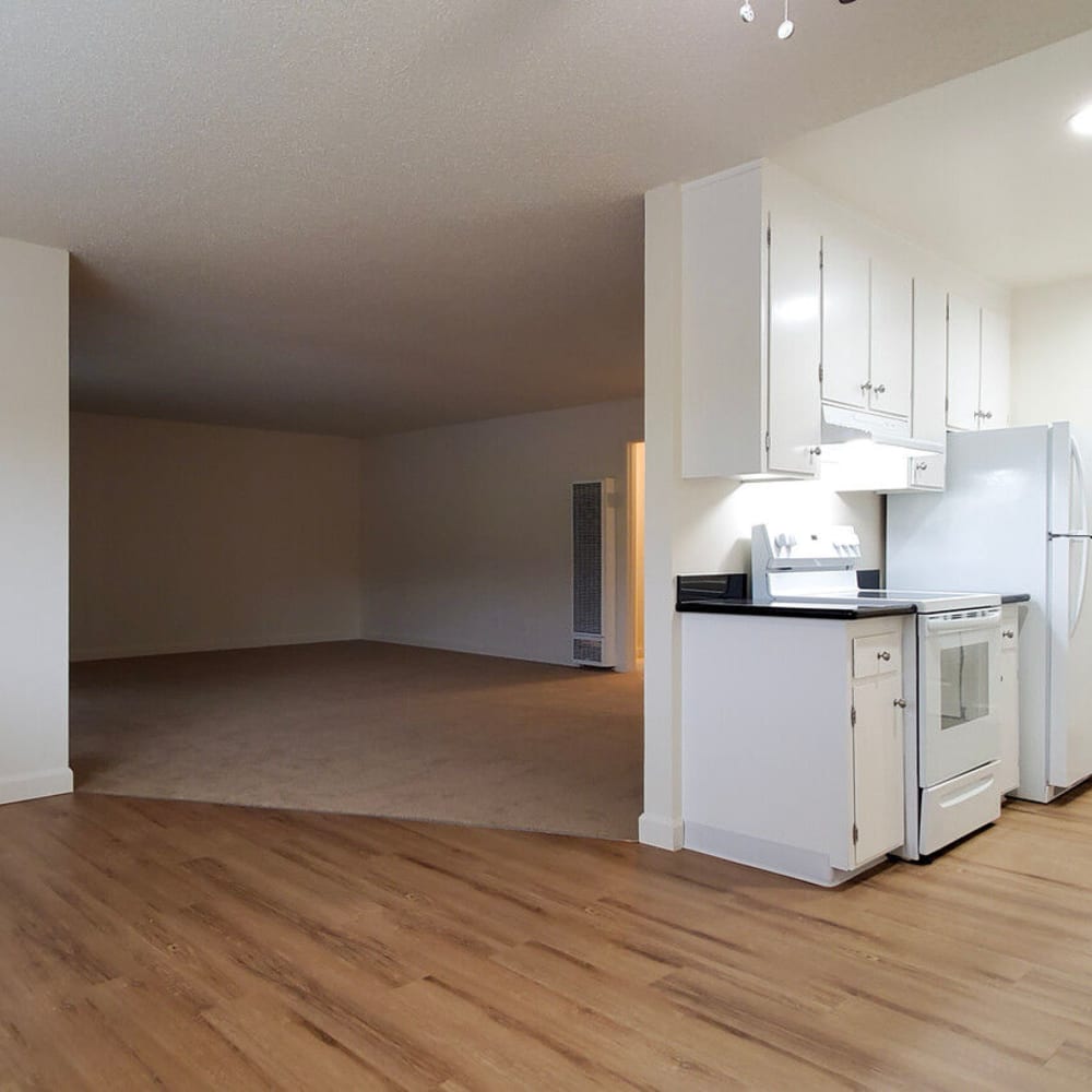 Wood-style flooring and bright white appliances and cabinetry in an apartment's kitchen at Mission Rock at Novato in Novato, California