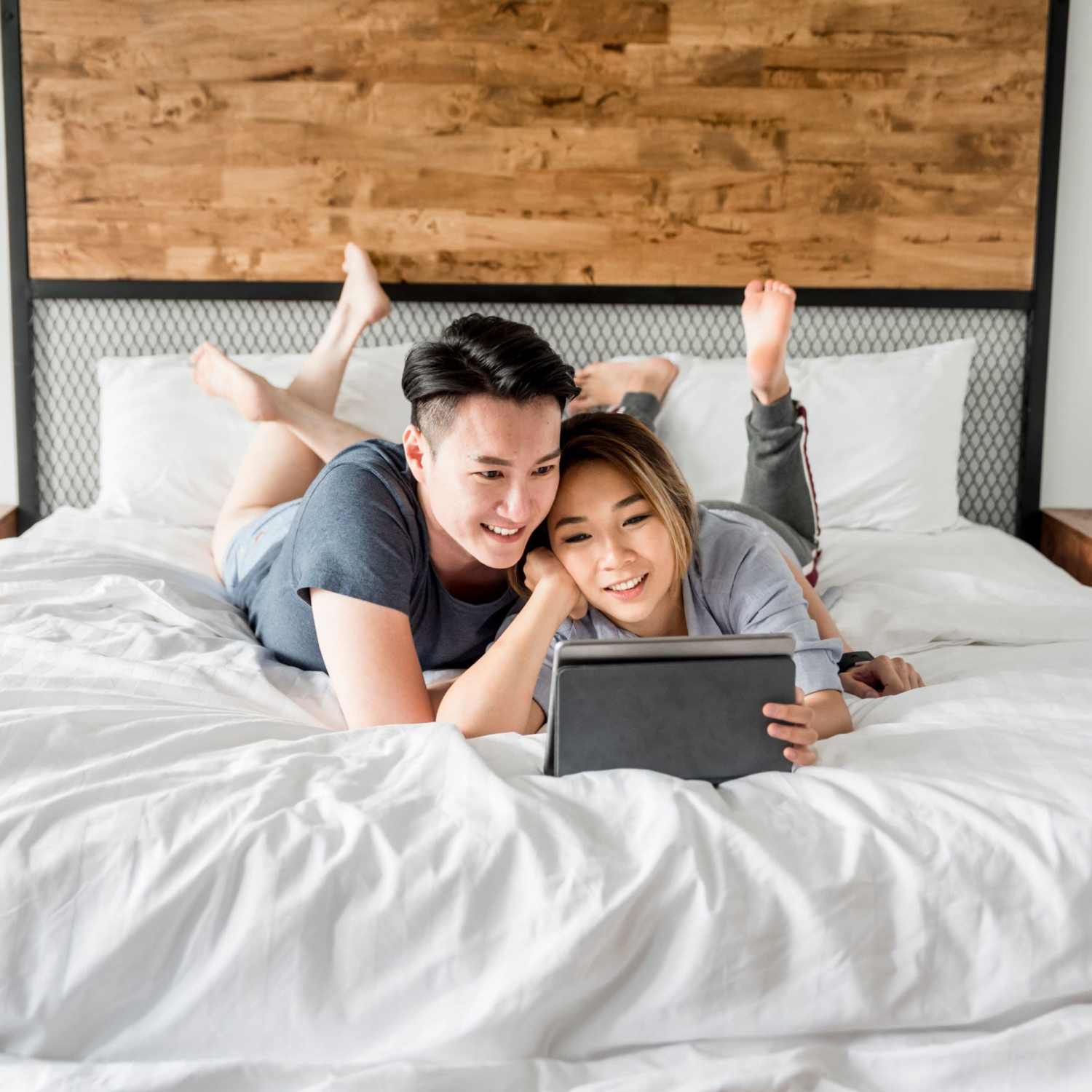 Couple lounging in their bed at Park Circle Village in North Charleston, South Carolina