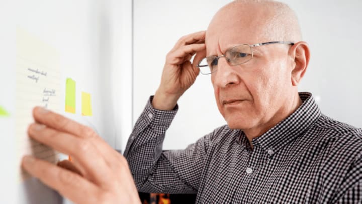 senior touching his head