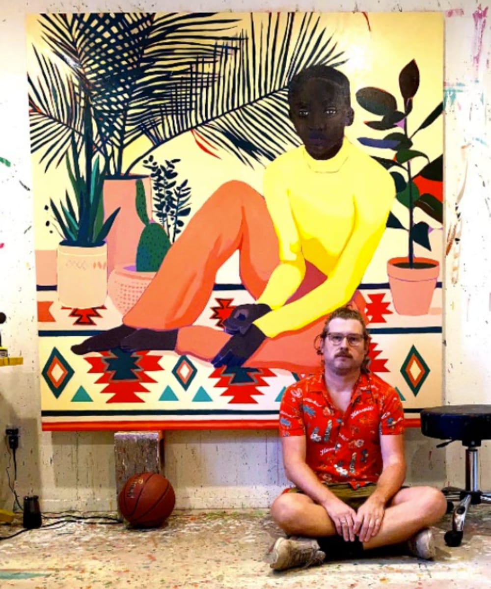 Artist Patrick Puckett seated on the ground in front of one of his large format paintings