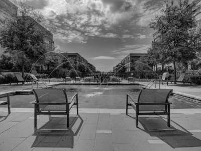 Courtyard at the park with lush greenery, benches, and a fountain at Flatiron District at Austin Ranch, The Colony, Texas