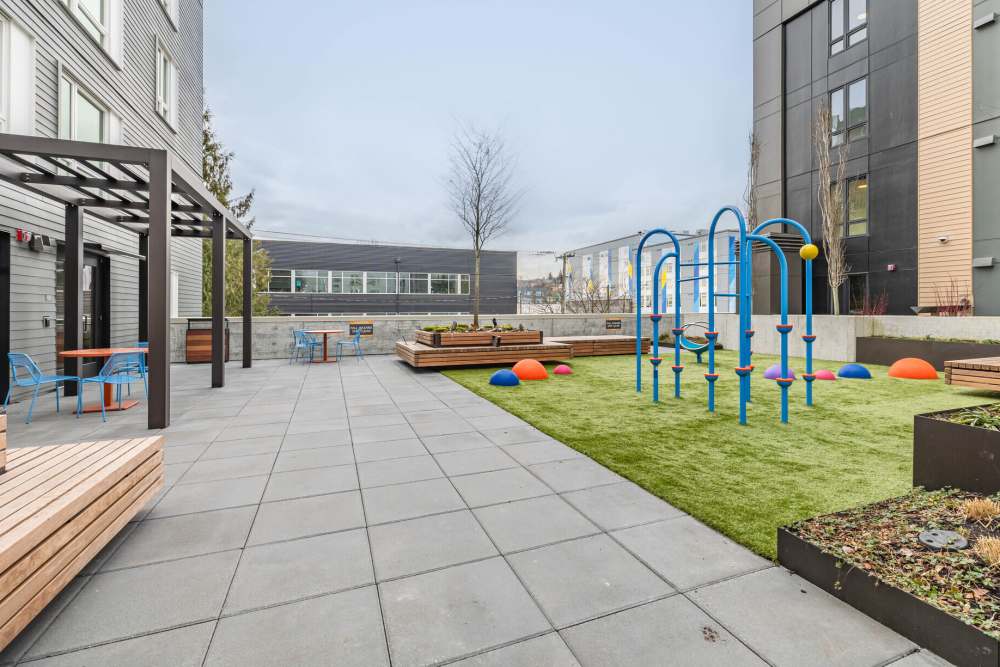Courtyard with seating and play area and pets welcome at Tahoma Valley Apartments in Seattle, Washington