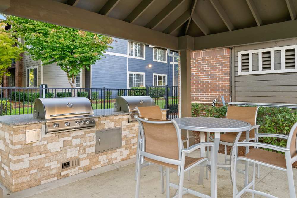Lounge chairs under the cabana with a flat-screen TV at Cortland Village Apartment Homes in Hillsboro, Oregon