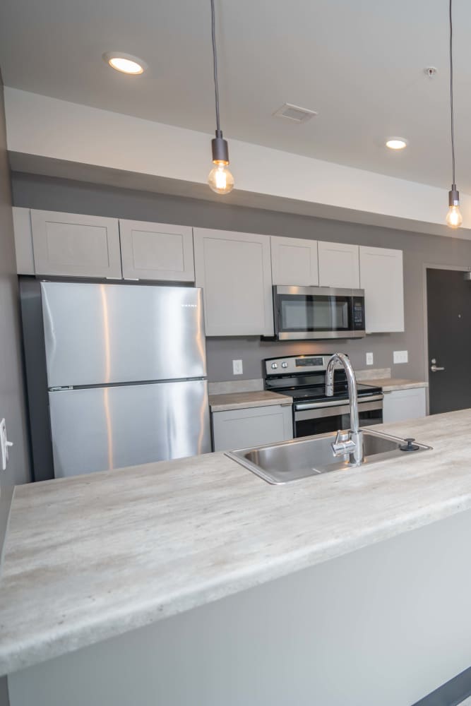 Spacious kitchen with refrigerator, stove, granite countertops and wood cabinetry at Diamond Place II in Grand Rapids, Michigan
