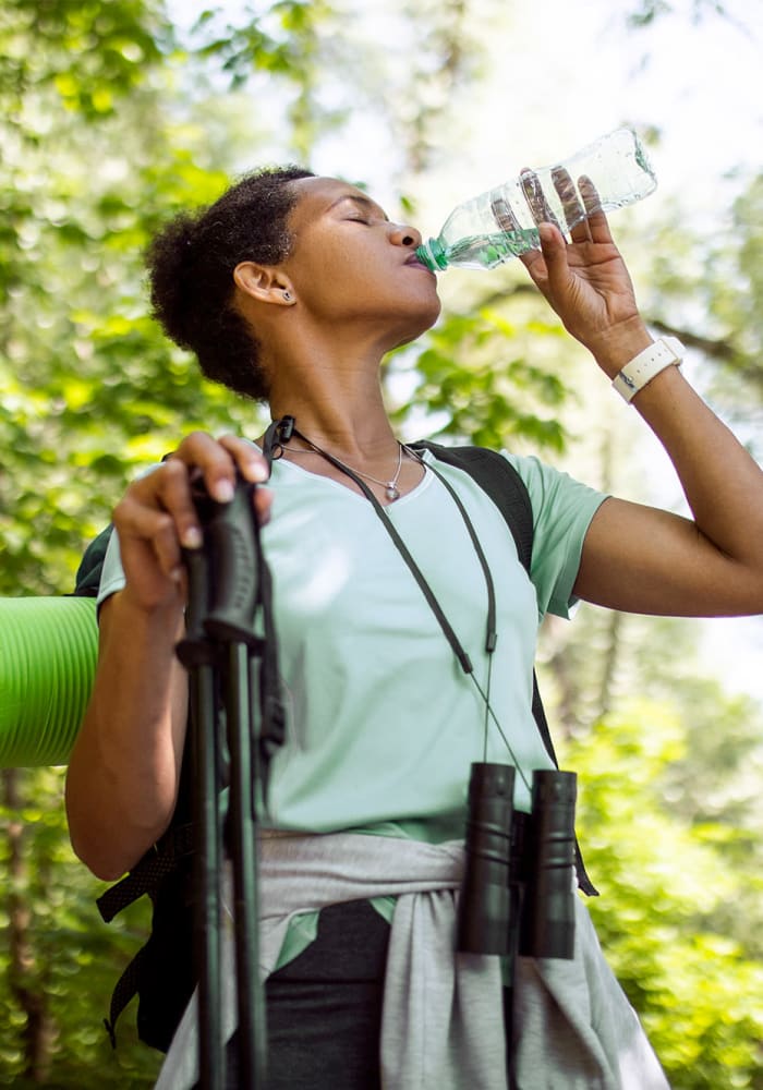 A woman drinking water while on a hike near Chace Lake Villas in Birmingham, Alabama