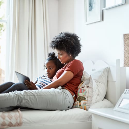 A mother and her daughter on a bed in a home at Madigan in Joint Base Lewis McChord, Washington