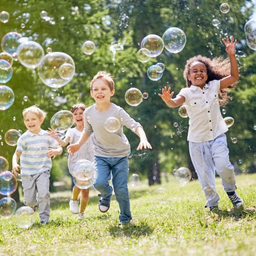 Children running through bubbles at Riverview Village in Indian Head, Maryland