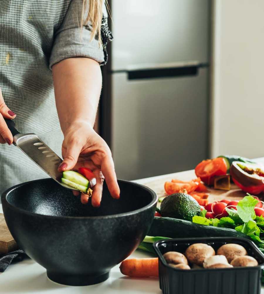 Resident preparing vegetables in their kitchen with stainless steel appliances at Parkwood Oaks in Bedford, Texas