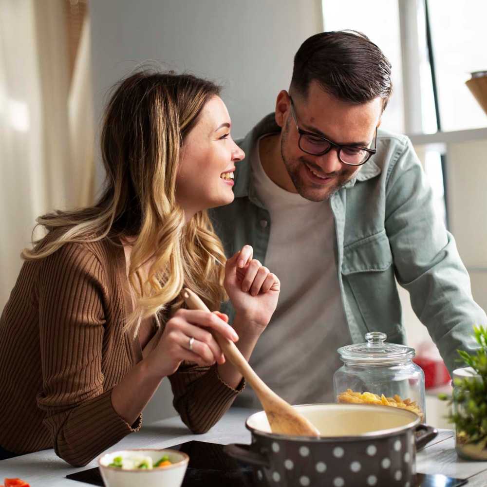 Couple cooking on an electric stove at Arrowhead Park Apartments in Lakewood, Washington, 