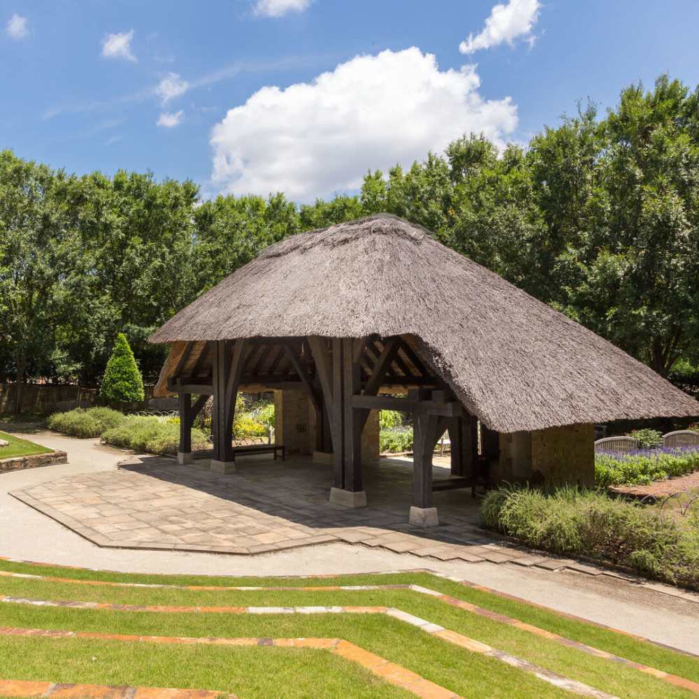 Seating area with shade surrounded by greenery at Tapestry on Vaughn in Montgomery, Alabama