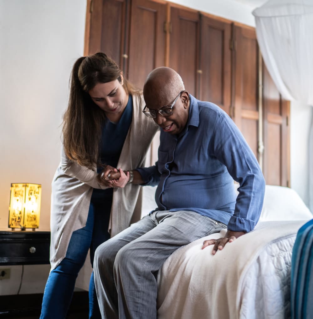 Caregiver helping a resident out of bed at Blossom Ridge in Oakland Charter Township, Michigan