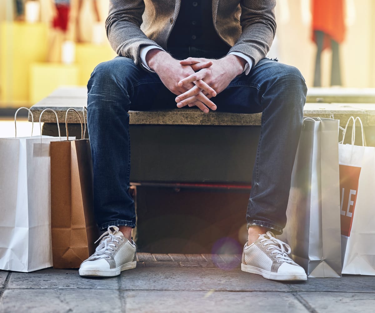 Man sitting with shopping bags near Double Tree Apartments in El Paso, Texas