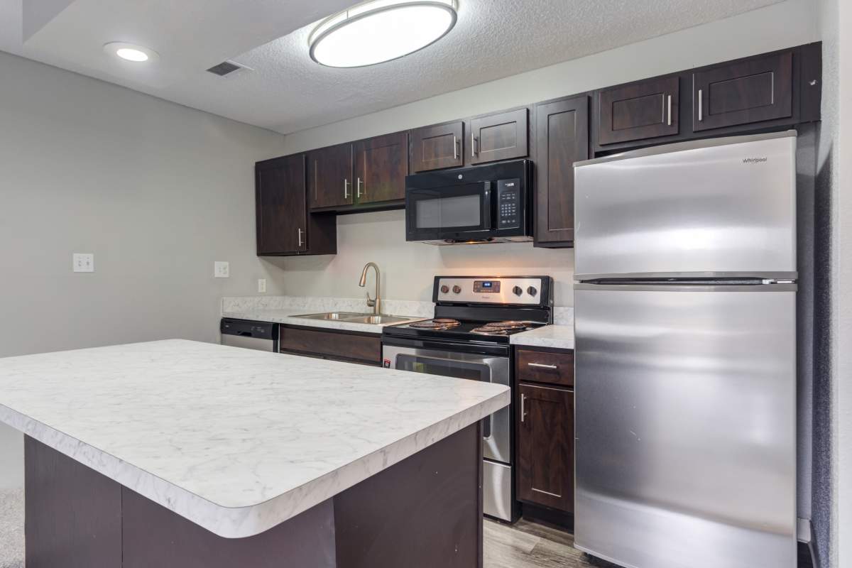 Fully equipped kitchen with espresso cabinets and stainless appliances at The Lakes of Schaumburg Apartment Homes in Schaumburg, Illinois