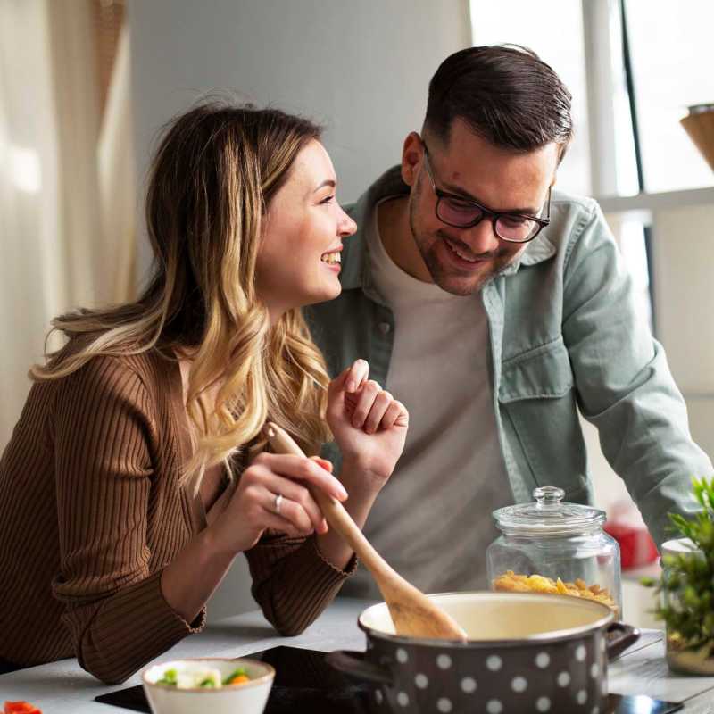 Resident cooking a delicious meal in the well-equipped kitchen of his apartment at Branch Creek Apartments in Carrollton, Texas