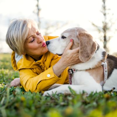 A woman and her dog lay in the grass at McLoughlin Place Senior Living in Oregon City, Oregon