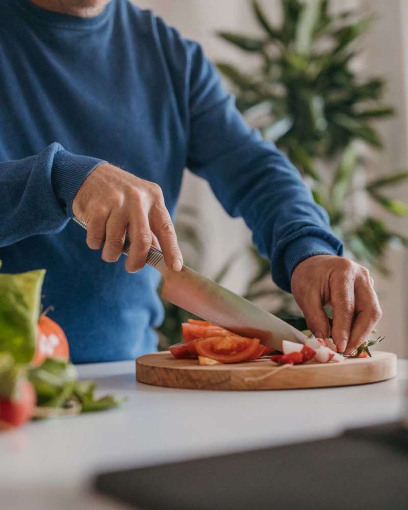 Resident chopping vegetables in his fully equipped kitchen at Octave in Davis, California