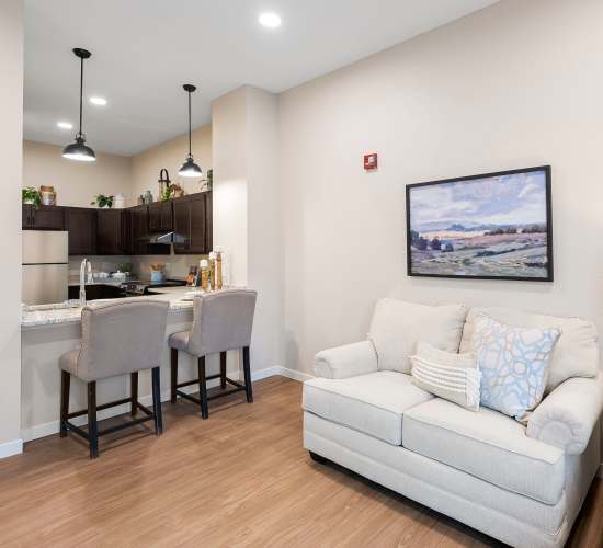 KItchen and living room in unit at Amira Choice Champlin in Champlin, Minnesota.