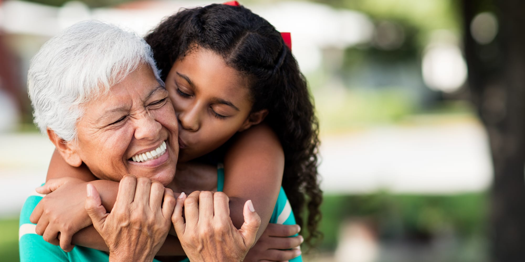 Grandmother and granddaughter hugging outside