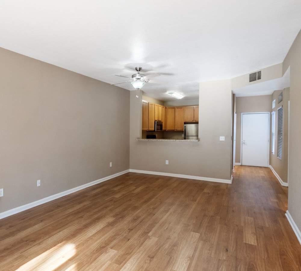 Hardwood-style flooring in living room with pass through kitchen window at Larkspur Woods in Sacramento, California