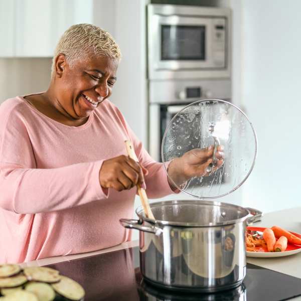 A resident prepares a meal in her apartment at Attain at Towne Place, Chesapeake, Virginia