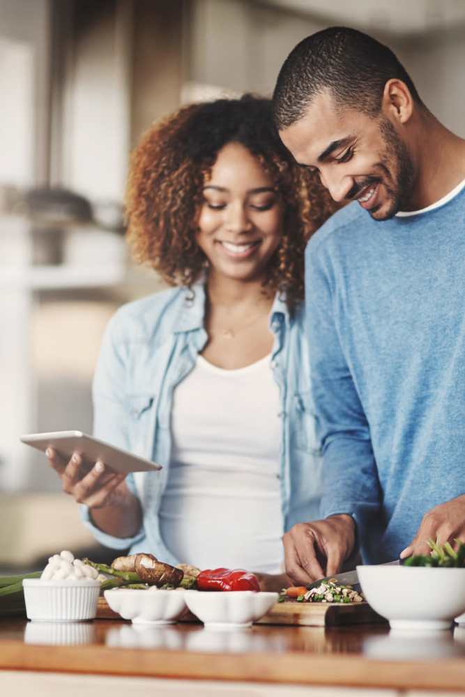 Couple whipping up a fresh meal in their modern kitchen at Sulzbacher Village in Jacksonville, Florida
