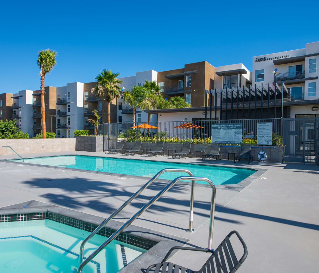 Hot tub and swimming pool with resident buildings in background at IMT Sherman Circle in Van Nuys, CA