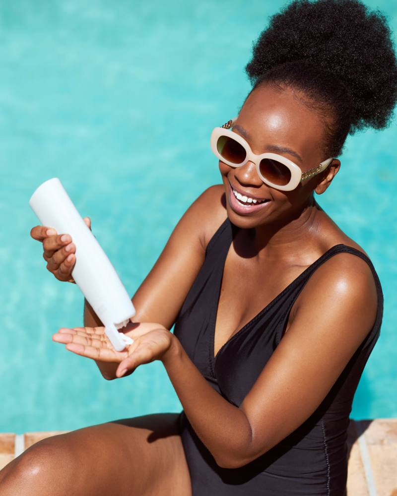 Resident putting on sunscreen by the swimming pool at Octave in Davis, California