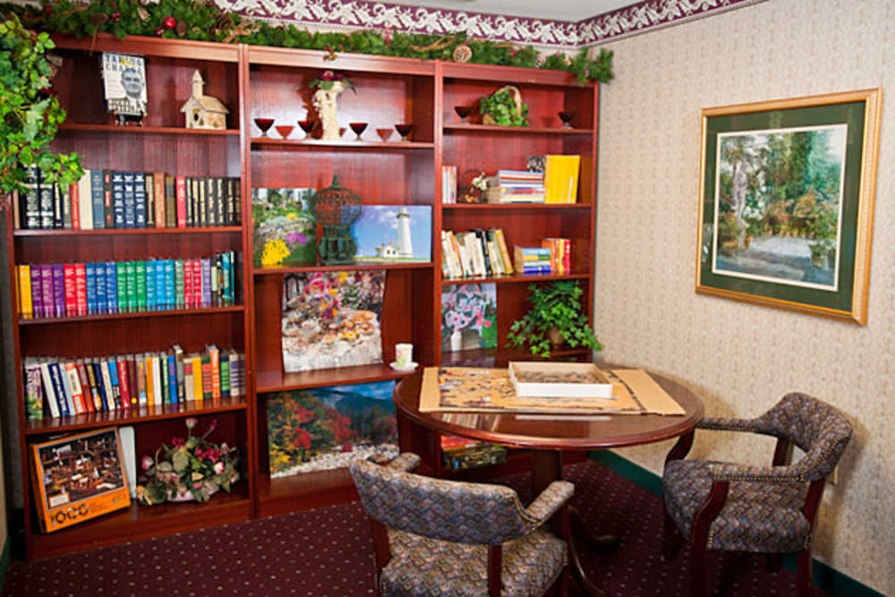 Well stoked oak bookshelf with seating at Cambridge Square Assisted Living in Rosenberg, Texas